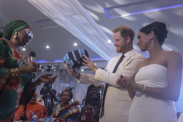 Britain's Prince Harry and Meghan, Duchess of Sussex, receiving a traditio<em></em>nal Nigerian outfit during their visit to the Nigerian Defence Headquarters in Abuja.