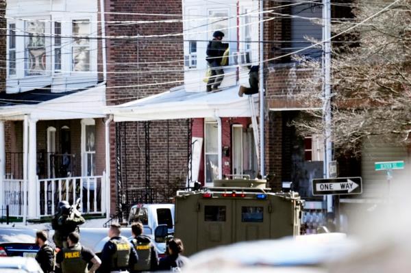 Police surround a home in Trenton, N.J., Saturday, March 16, 2024. A suspect has barricaded himself in the home and was holding hostages after shooting three people to death in suburban Philadelphia. (AP Photo/Matt Rourke)