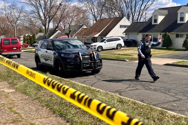 A police officer patrols a neighborhood during an active shooter situation in Levittown, a community within Falls Township, Pennsylvania