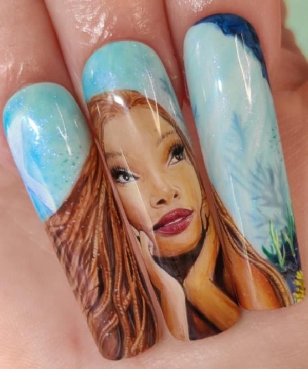 Kassie Payne's Little Mermaid nail set. Photo released September 28 2023. See SWNS story SWTPnails. A mum-of-one who quit her job to become a nail artist says trolls say her ?900 sets are overpriced ? but she says they?re collectable art. Kassie Payne, 34, paints elaborate portraits o<em></em>nto press-on nails, sometimes as small as just three centimetres. Her most intricate designs can take up to 45 hours to complete. The mum says trolls tell her no one would pay ?900 a set for fake nails - but she hits back by explaining they?re collectable art pieces.