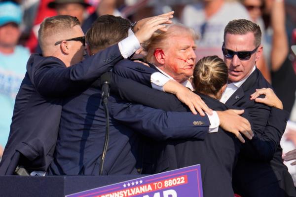 Republican presidential candidate former President Do<em></em>nald Trump is surrounded by U.S. Secret Service agents as he is helped off the stage at a campaign rally in Butler, Pa., July 13, 2024. 