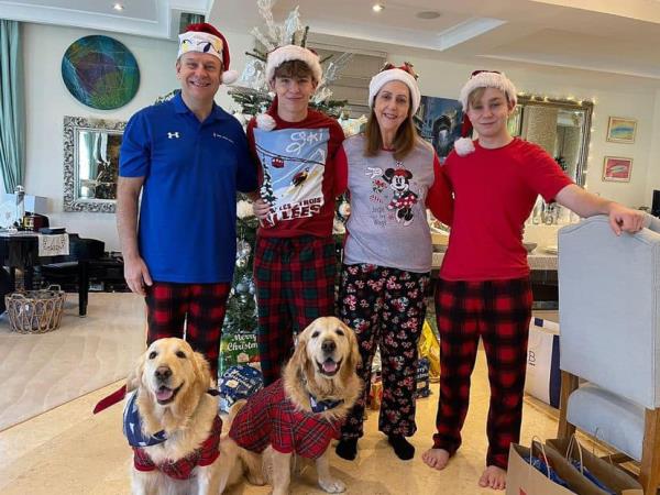 Harding and his family posing for a holiday photo along with their two golden retrievers. 