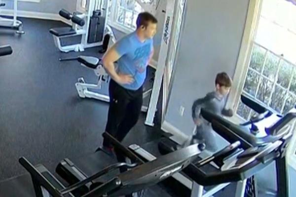 The boy was running on the treadmill for several minutes before his father appeared and stood nearby.