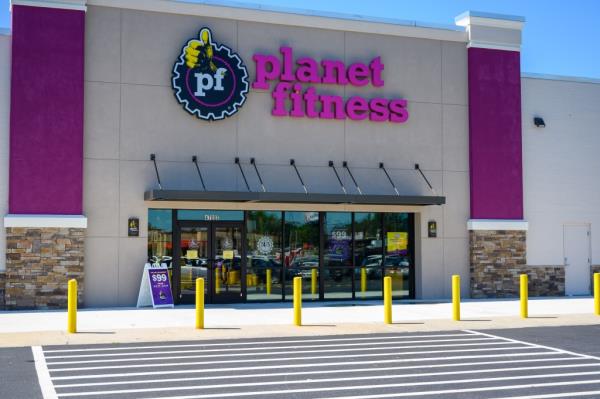 Exterior view of a Planet Fitness gym building with a sign on the front