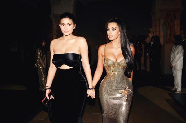 Kim Kardashian and Kylie Jenner attending the Heavenly Bodies: Fashion & The Catholic Imagination Costume Institute Gala at The Metropolitan Museum of Art, holding hands and walking