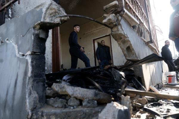 A Palestinian cleans up the damage after an Israeli military raid on the town of Tubas in the West Bank on Sunday, Dec. 10, 2023. (AP Photo/Majdi Mohammed)