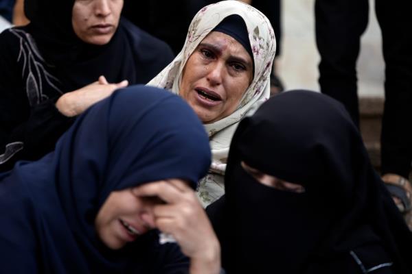 Palestinians mourn relatives killed in the Israeli bombardment of the Gaza Strip outside a morgue in Khan Younis on Sunday, Dec. 10, 2023. (AP Photo/Mohammed Dahman)