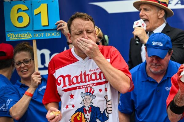 Joey Chestnut stuffing his mouth with a hot dog at the Nathan's contest.