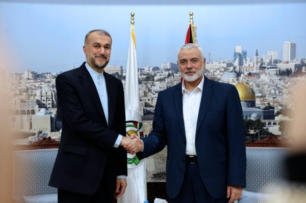 Iran's Foreign Minister Hossein Amirabdollahian, left, and Hamas chief Ismail Haniyeh shake hands during a meeting in Doha, Qatar on Dec. 20, 2023.