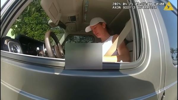 Emotio<em></em>nal Gisele Bundchen in a white hat, in her car, after being pulled over by police in Surfside, Florida