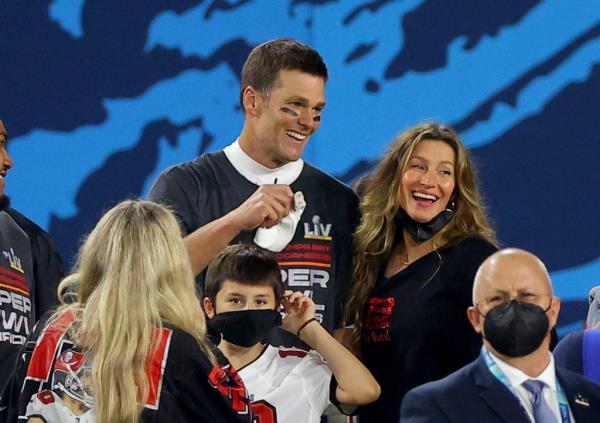 Tom Brady and Gisele Bündchen celebrating post Super Bowl win with their child against a blue background