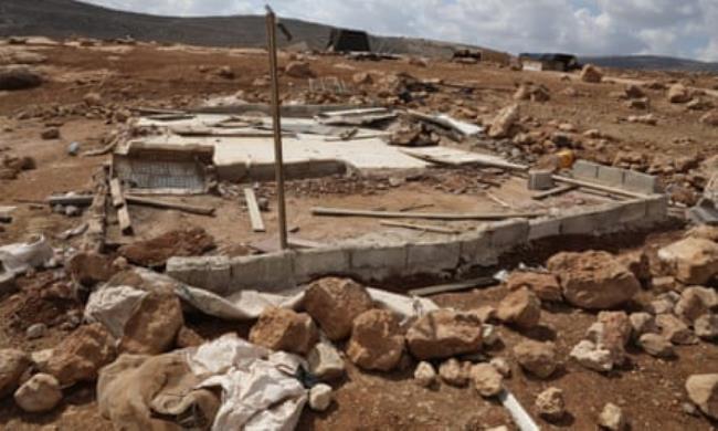 ruin of small house on the hillside with o<em></em>nly stone foundations and rubble remaining