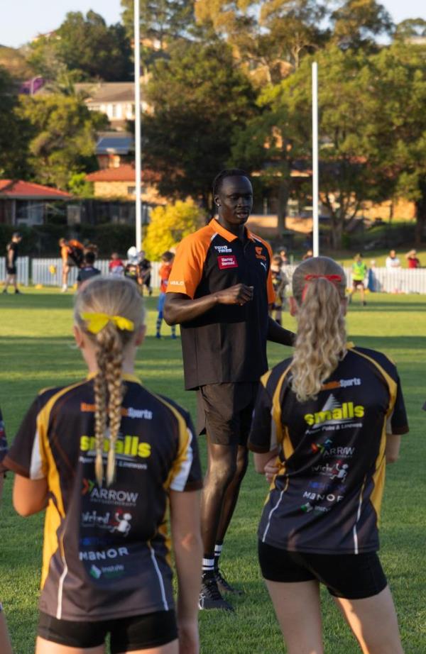 GWS Giants defender Leek Aleer takes kids through an Aussie Rules drill at Baulkham Hills on Wednesday.